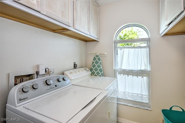 washroom featuring washer and dryer and cabinets