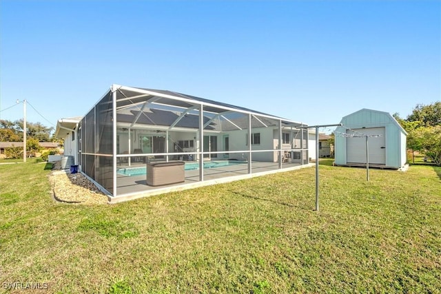 rear view of house featuring a patio area, a lanai, a storage unit, and a lawn