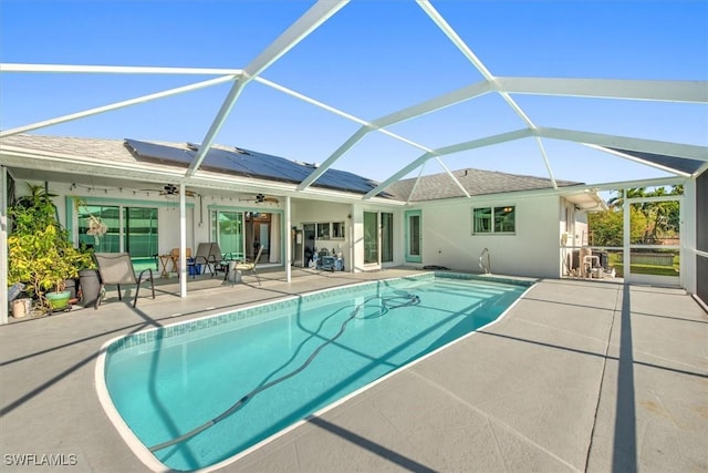 view of swimming pool featuring ceiling fan, a lanai, and a patio area