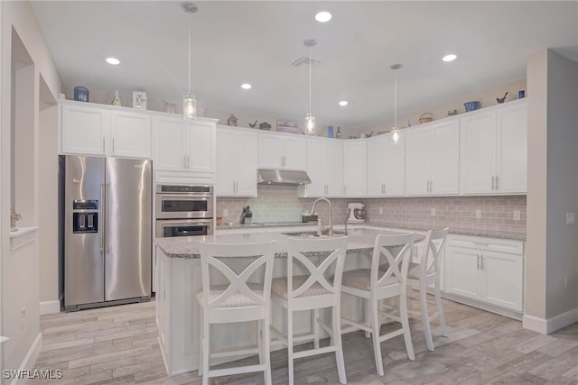 kitchen with white cabinetry, hanging light fixtures, and appliances with stainless steel finishes