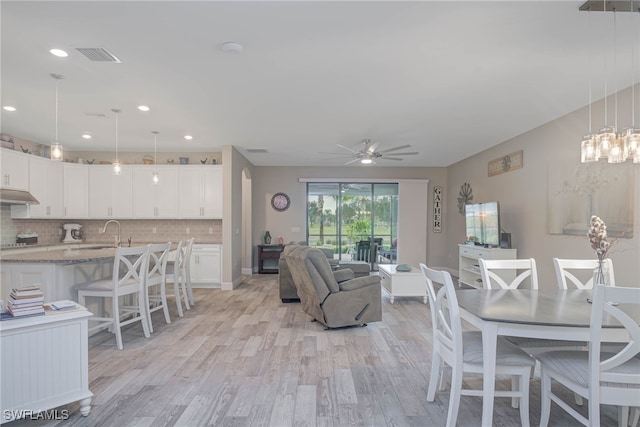 living room featuring ceiling fan, sink, and light hardwood / wood-style floors