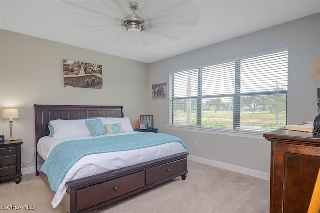 bedroom with ceiling fan, multiple windows, and light carpet