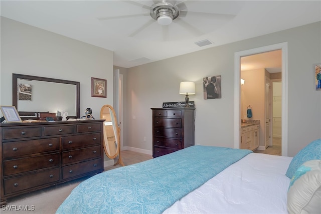 carpeted bedroom with ceiling fan and ensuite bath