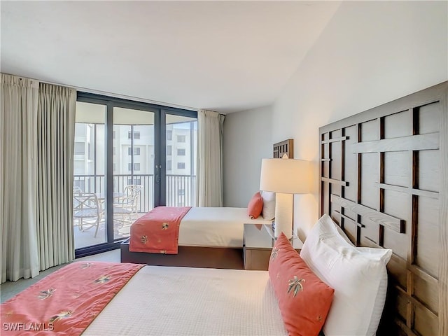 bedroom featuring access to exterior, a wall of windows, and french doors