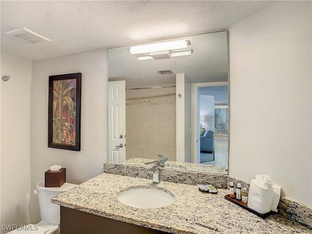 bathroom with vanity, toilet, and walk in shower