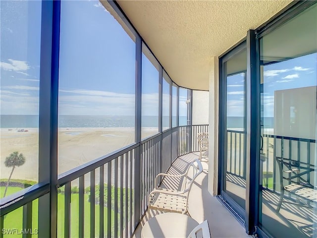 sunroom / solarium with a beach view and a water view