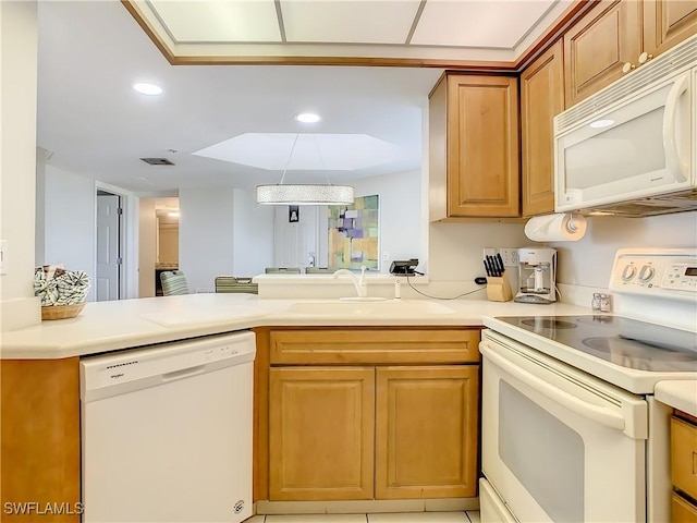 kitchen featuring sink, white appliances, and kitchen peninsula