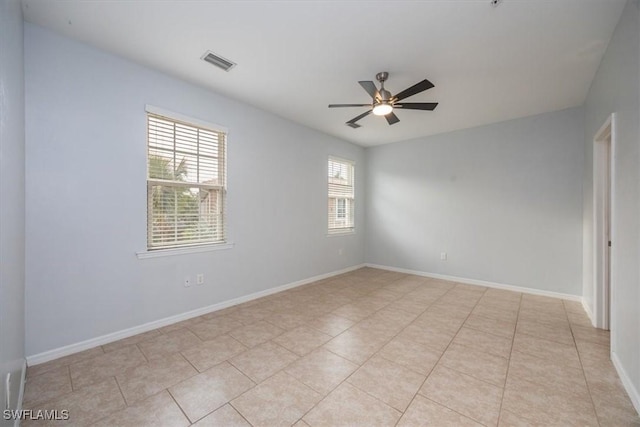 tiled spare room featuring ceiling fan