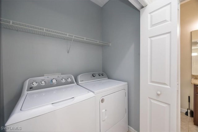 laundry area with light tile patterned floors and separate washer and dryer