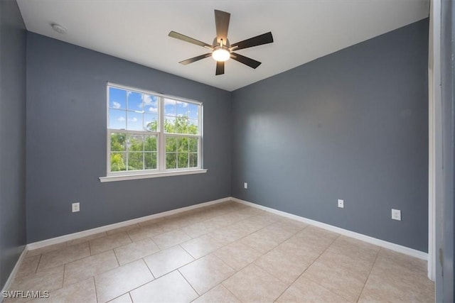 spare room with ceiling fan and light tile patterned flooring