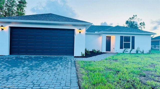 ranch-style home with a garage, a front lawn, decorative driveway, and stucco siding