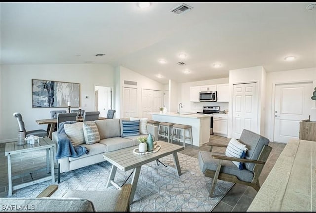 living room with lofted ceiling, baseboards, and visible vents