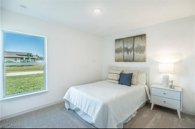 bedroom featuring light carpet and baseboards