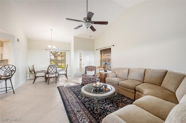 tiled living room with ceiling fan with notable chandelier and high vaulted ceiling