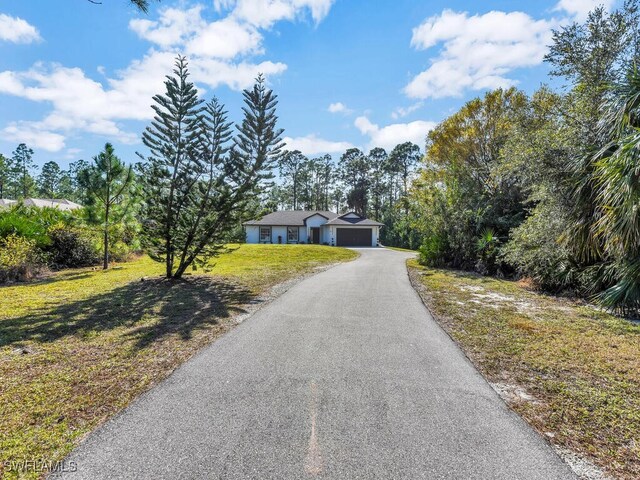 ranch-style house with a garage and a front lawn