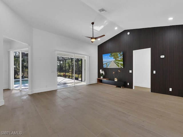 unfurnished living room with ceiling fan, high vaulted ceiling, a wealth of natural light, and light hardwood / wood-style floors