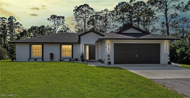 ranch-style home featuring a yard and a garage