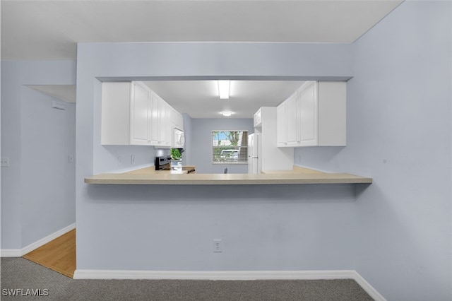 kitchen featuring white appliances, white cabinetry, and carpet