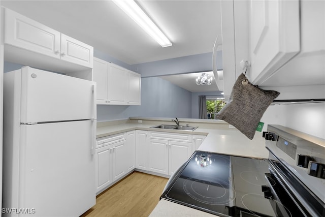 kitchen featuring sink, white cabinetry, a chandelier, and white fridge