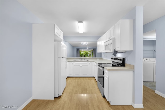 kitchen featuring white appliances, washing machine and clothes dryer, white cabinetry, sink, and light hardwood / wood-style flooring