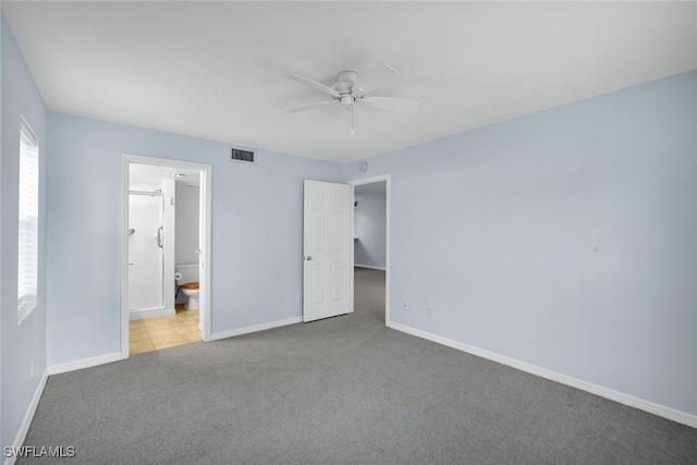 unfurnished bedroom featuring light colored carpet, ensuite bath, and ceiling fan