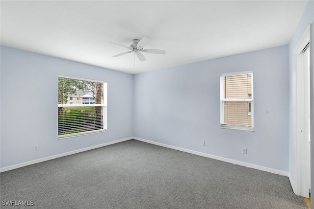 carpeted spare room featuring ceiling fan and a wealth of natural light