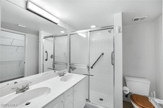 bathroom with vanity, a shower with shower door, and toilet