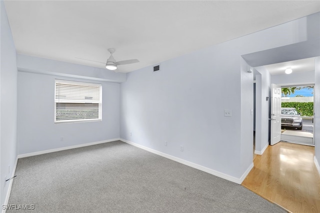 carpeted spare room featuring ceiling fan