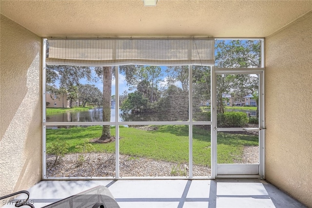 unfurnished sunroom with a water view