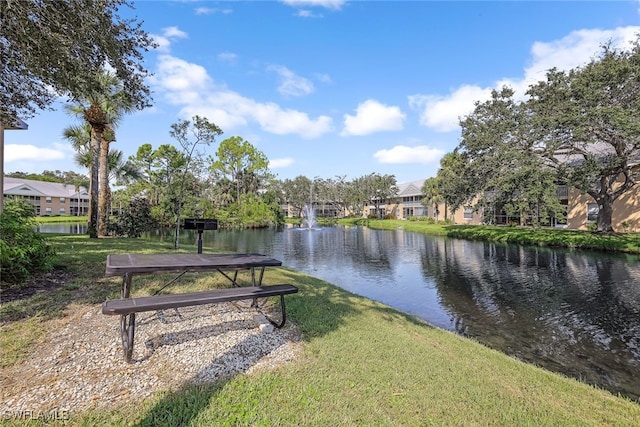 view of community with a lawn and a water view