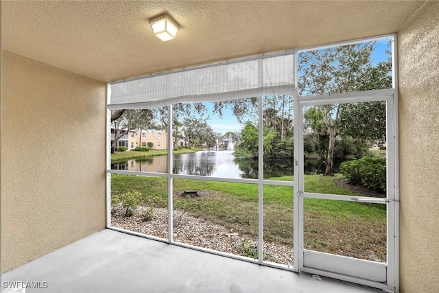 unfurnished sunroom with a water view