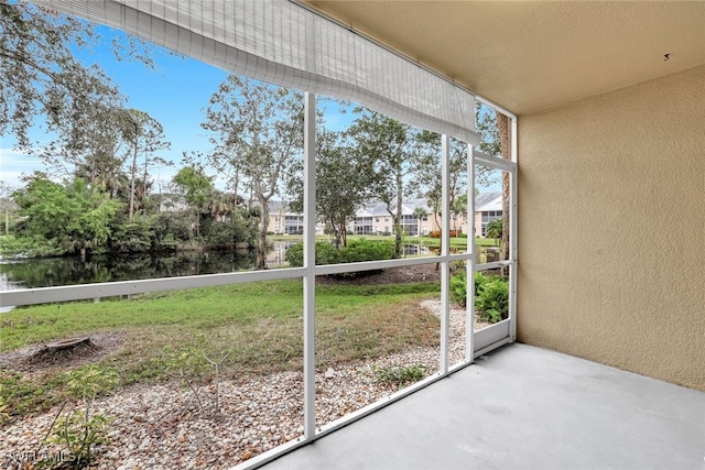 unfurnished sunroom with a water view