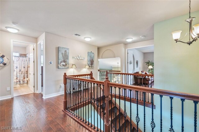 hallway with a notable chandelier and hardwood / wood-style flooring