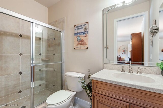 bathroom with walk in shower, vanity, and toilet