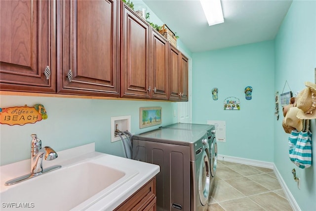 clothes washing area featuring sink, cabinets, and washing machine and dryer