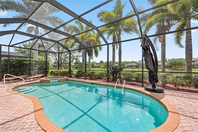 view of swimming pool with a lanai, a patio, and an in ground hot tub