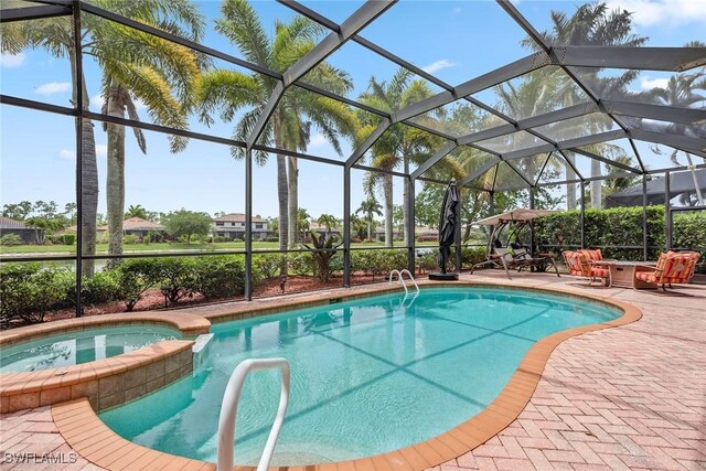 view of swimming pool featuring an in ground hot tub, glass enclosure, and a patio