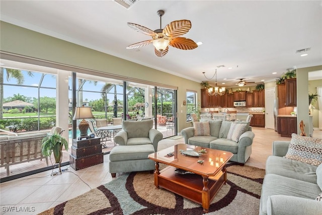 living room with ornamental molding, ceiling fan with notable chandelier, and light tile patterned floors