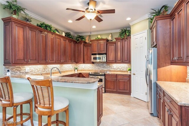 kitchen featuring kitchen peninsula, stainless steel appliances, ornamental molding, and decorative backsplash