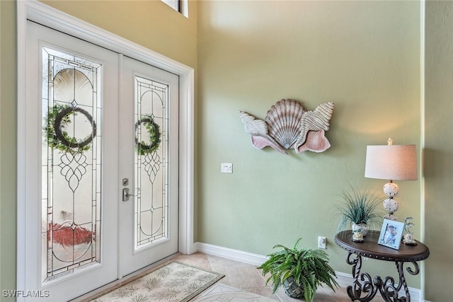 entrance foyer featuring french doors and light tile patterned floors