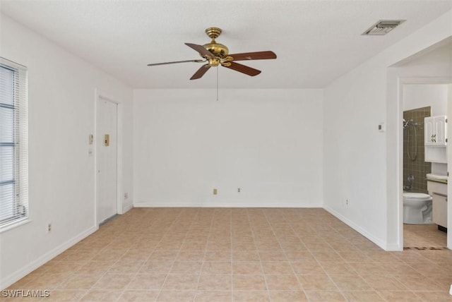 unfurnished room with ceiling fan and light tile patterned floors