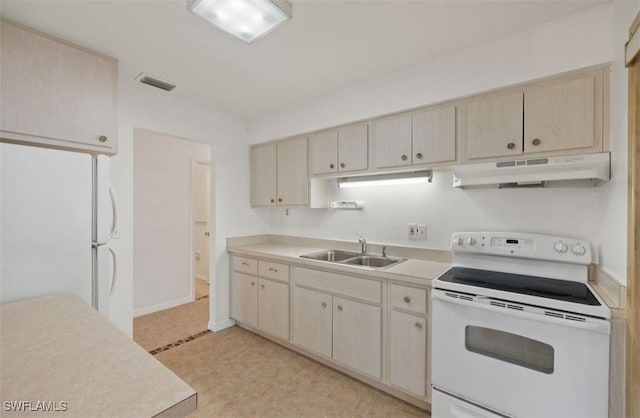 kitchen featuring light brown cabinetry, sink, and white appliances