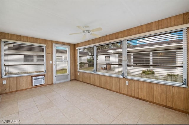 unfurnished sunroom featuring ceiling fan and a wall mounted air conditioner