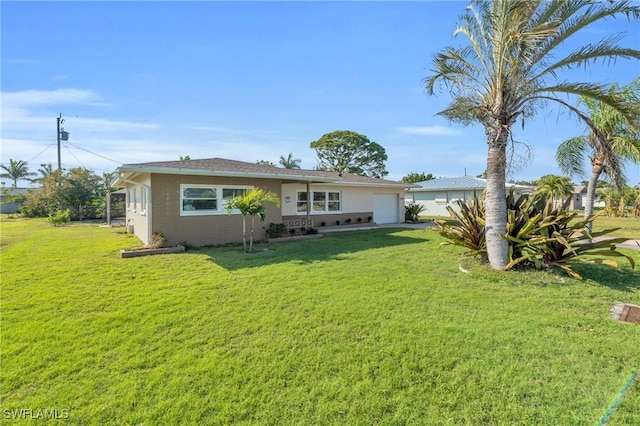 rear view of property featuring a garage and a lawn