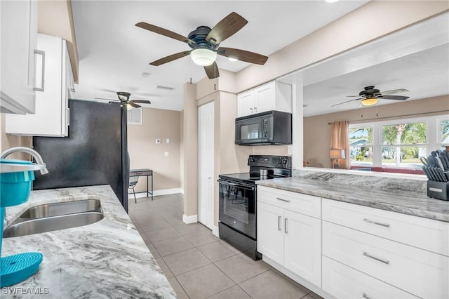 kitchen featuring light stone counters, sink, black appliances, light tile patterned floors, and white cabinetry