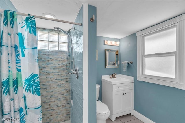 bathroom featuring tile patterned flooring, vanity, toilet, and walk in shower