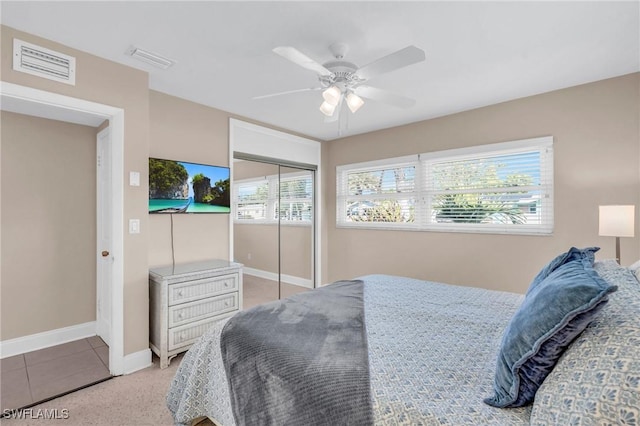 tiled bedroom featuring ceiling fan and a closet