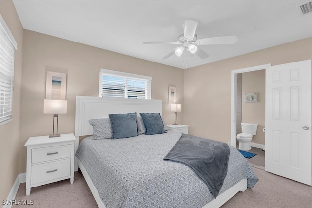 bedroom featuring connected bathroom, light colored carpet, and ceiling fan