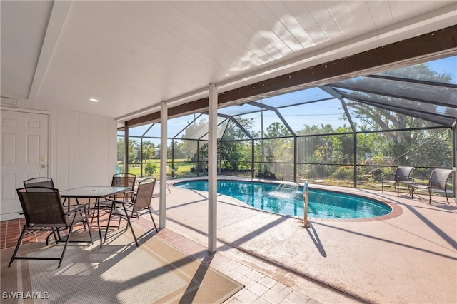 view of pool with a patio area, pool water feature, and glass enclosure