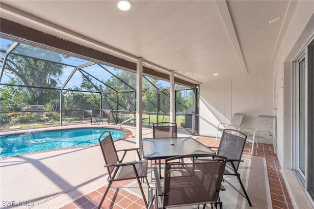 view of swimming pool with pool water feature, a patio area, and a lanai